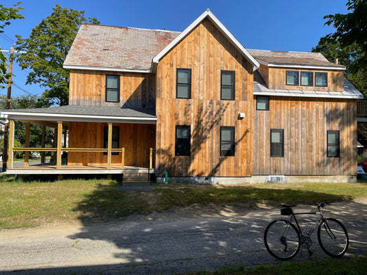 energy-efficient affordable housing, bright blue sky, bicycle in foreground
